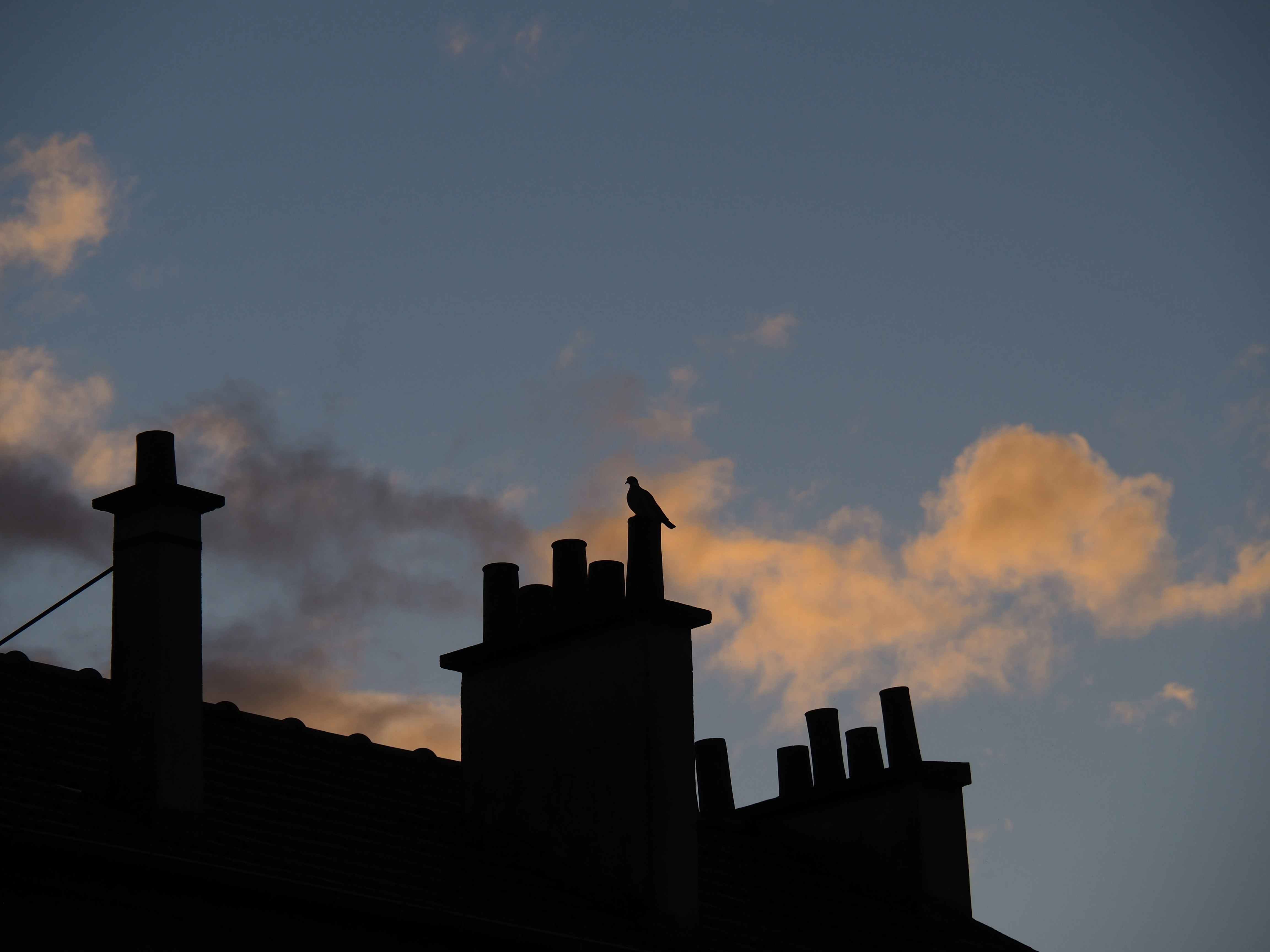 silhouette of building under cloudy sky during sunset